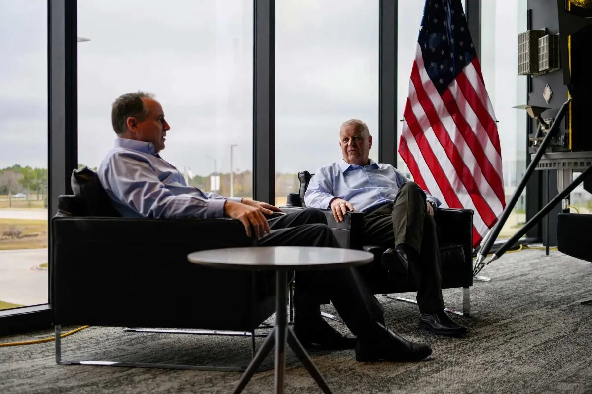 استیون آلتموس و کمال غفاریان درمقابل پنجره و در کنار پرچم آمریکا نشسته اند